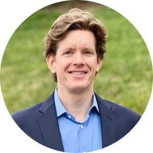 Dr. Michael Dobson wears a light blue dress shirt and a navy blue blazer