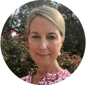 Shannon Gearing smiling in front of a flower bush