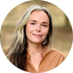 Nurse Practitioner Rachel Hess wears a tan V-neck top in front of a winter landscape