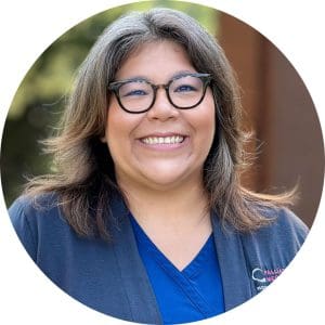 Rachael Ann Anderson wears a navy Palliative Medicine cardigan over Hospice of the Piedmont scrubs