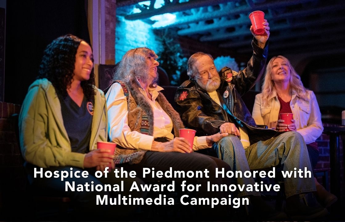 A hospice patient in a wheel chair raises a red solo cup as while attending a rock concert. He's accompanied by his hospice nurse, wife and daughter